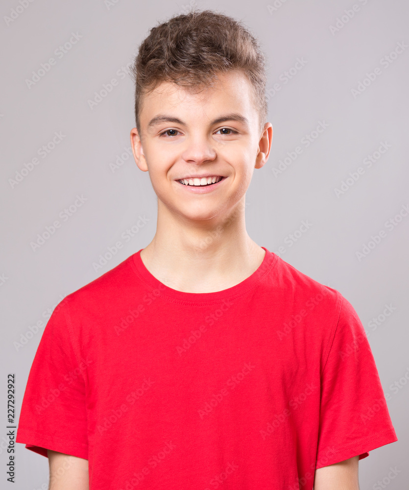 Close up emotional portrait of caucasian teen boy. Handsome smiling guy. Funny cut teenager on gray background. Happy child looking at camera. Close up emotional portrait of caucasian teen boy. Handsome smiling guy. Funny cut teenager on gray background. Happy child looking at camera.