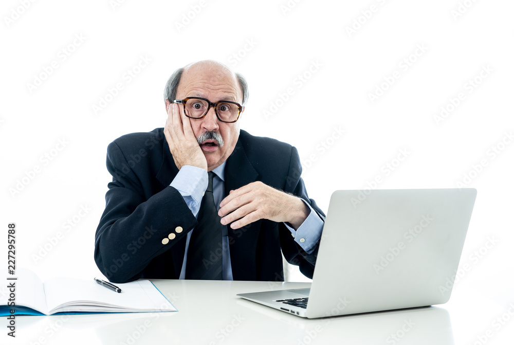 Overwhelmed and tired old businessman working with laptop feeling angry at office Overwhelmed and tired old businessman working with laptop feeling angry at office