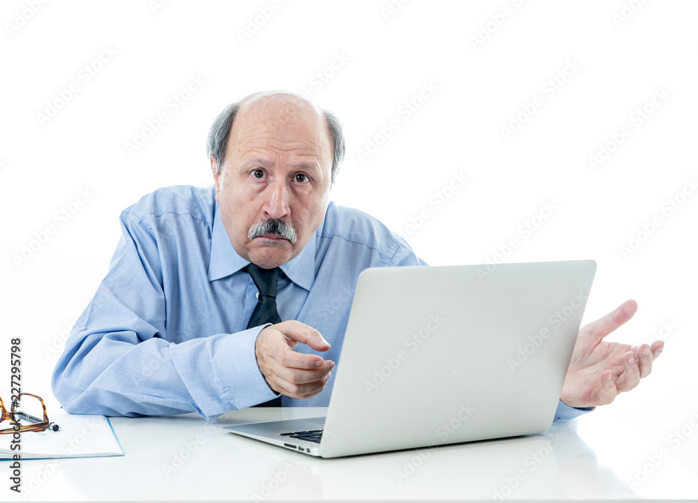 Overwhelmed and tired old businessman working with laptop feeling angry at office Overwhelmed and tired old businessman working with laptop feeling angry at office
