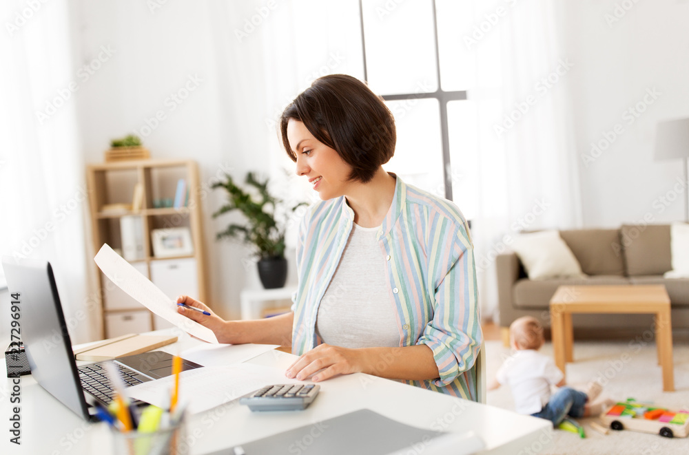 multi-tasking, freelance and motherhood concept - working mother with papers at laptop computer and baby boy at home office multi-tasking, freelance and motherhood concept - working mother with papers at laptop computer and baby boy at home office