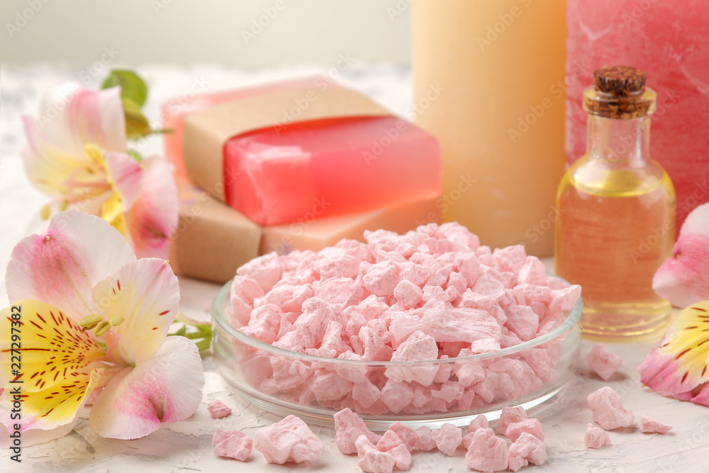 Spa composition with sea salt, aroma oils and handmade soap with flowers. spa concept. on a light background.