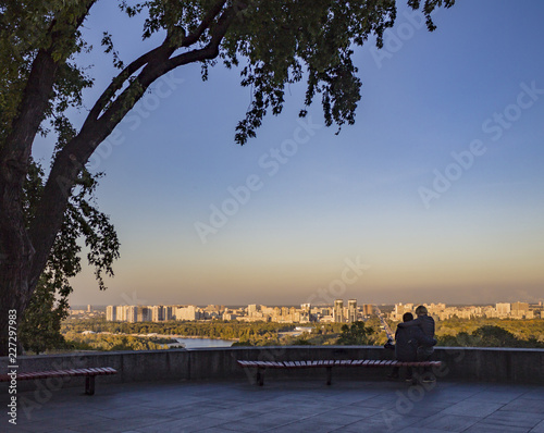 Urbanistic big modern city landscape and couple on bench