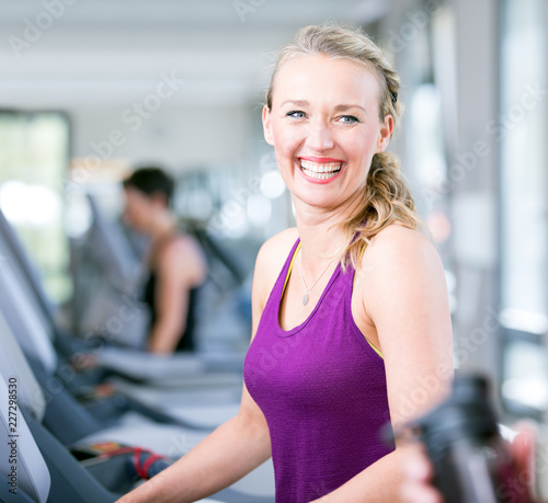 young beautiful woman are doing her sport running workout in the gym on a treadmill