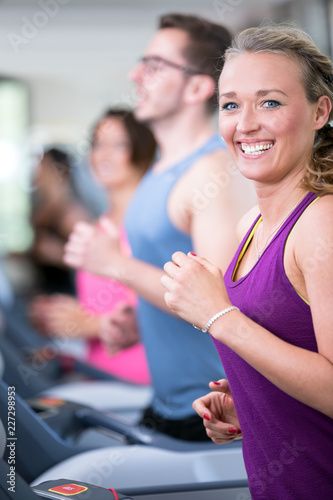 young beautiful woman are doing her sport running workout in the gym on a treadmill