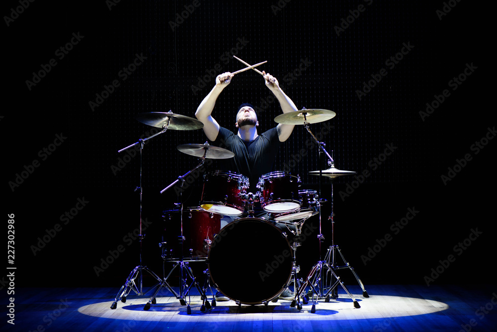 Fototapeta premium Drummer playing the drums with smoke and powder in the background