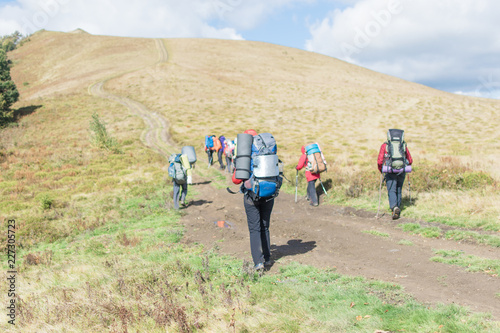 A group of people with backpacks hiking in the mountains.