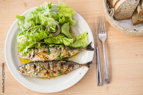 Two freshly barbecued sardines served with bread