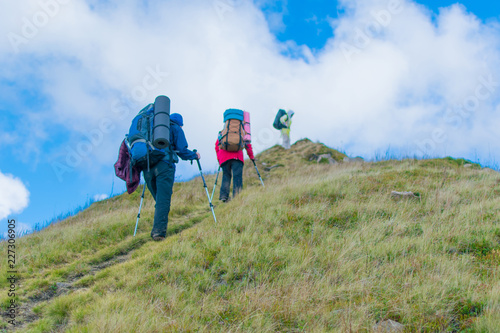A group of people with backpacks hiking in the mountains.
