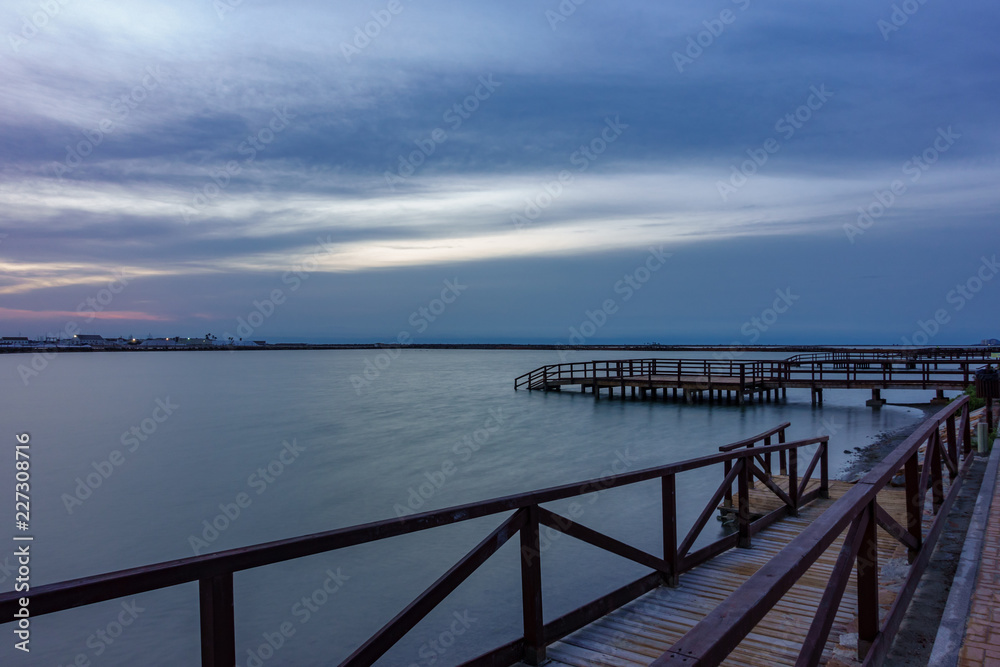 Long exposure of pier at sunrise with lake
