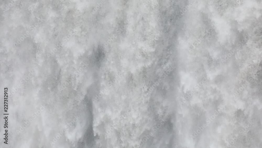 Powerful raging whitewater waterfall falling forcefully over a rocky edge. Crystal clear glacier water stream dropping over the cliff Powerful raging whitewater waterfall falling forcefully over a rocky edge. Crystal clear glacier water stream dropping over the cliff