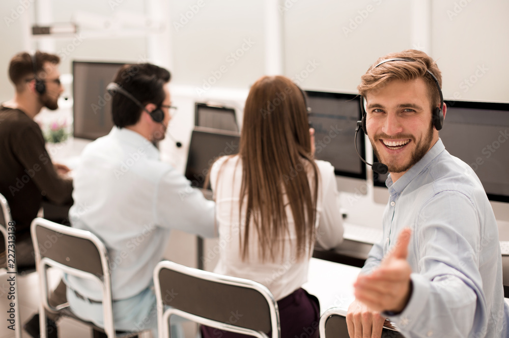 rear view. young customer service agent sitting at his Desk rear view. young customer service agent sitting at his Desk