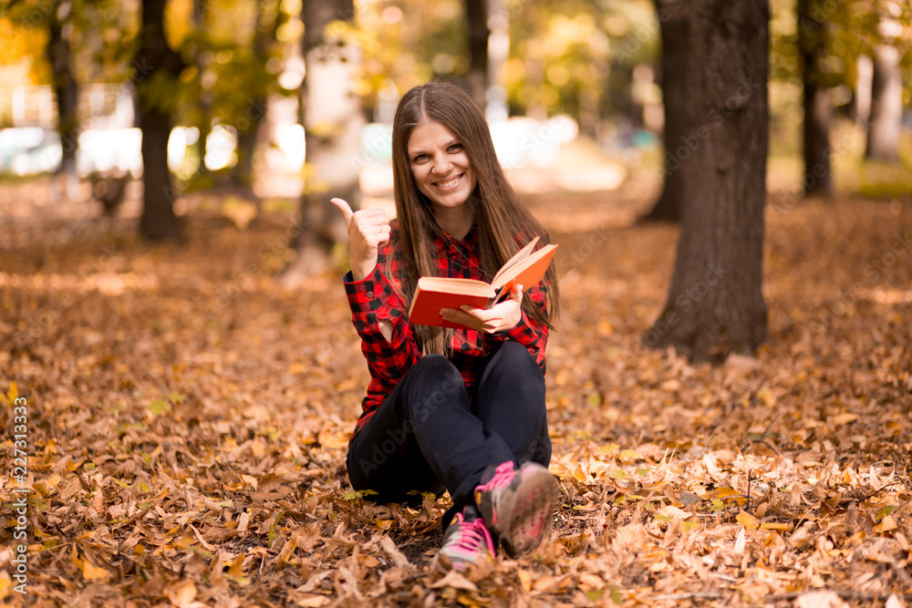 Beautiful girl in autumn park reading book. Girl reading Beautiful girl in autumn park reading book. Girl reading