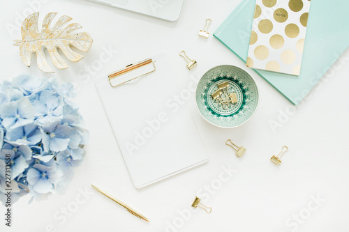 Modern home office desk workspace with blank paper clipboard, hydrangea flower bouquet on white background. Flat lay, top view mock up. photo