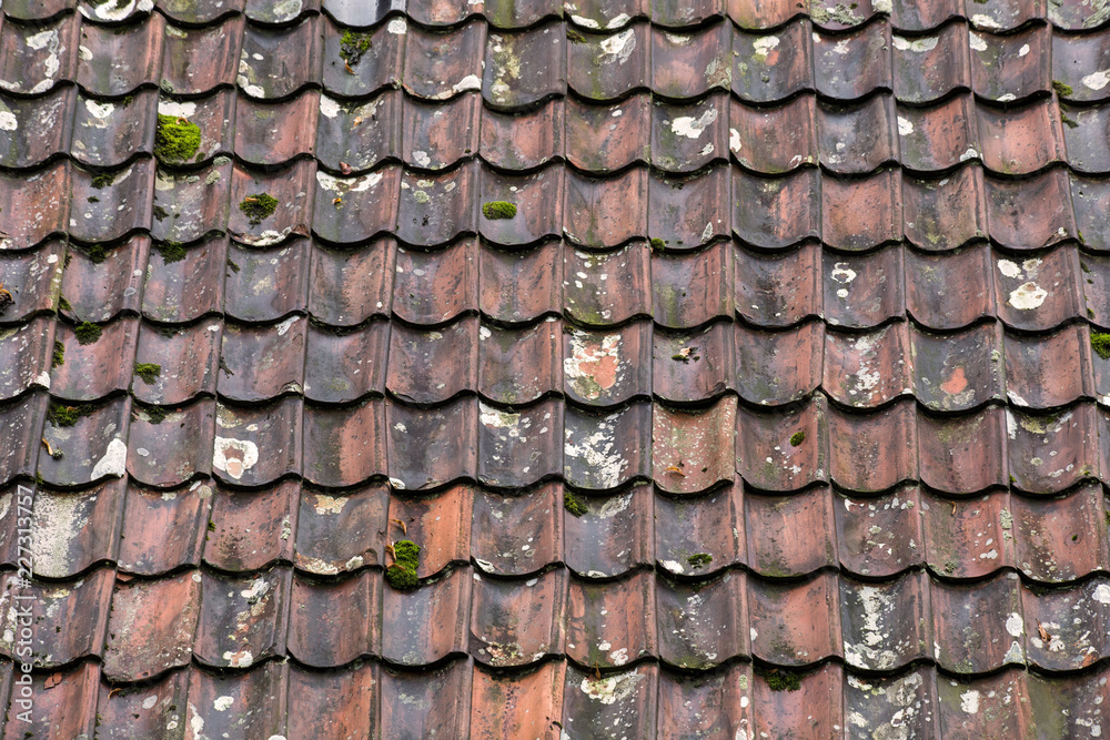 Old and ruined roof tiles close-up. Texture of a roof with old roof tiles.