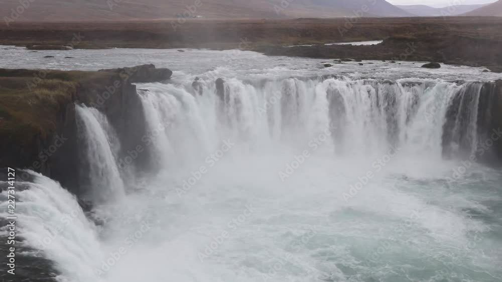 Powerful raging whitewater waterfall falling forcefully over a rocky edge. Crystal clear glacier water stream dropping over the cliff Powerful raging whitewater waterfall falling forcefully over a rocky edge. Crystal clear glacier water stream dropping over the cliff
