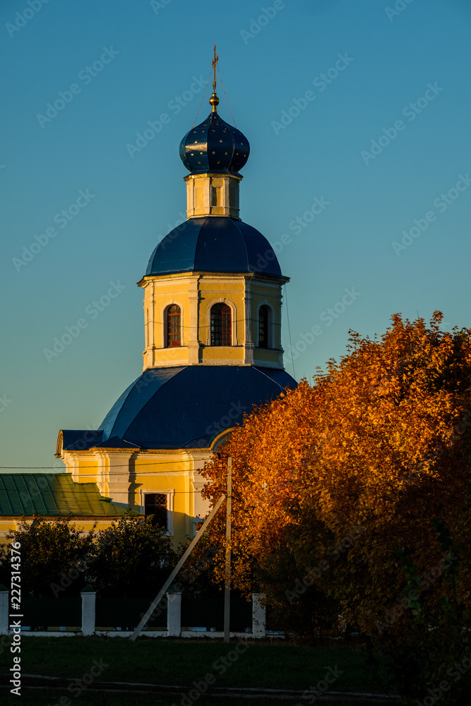 View of the Petropavlovskaya Church in the fall in Yasenevo at sunset. View of the Petropavlovskaya Church in the fall in Yasenevo at sunset.
