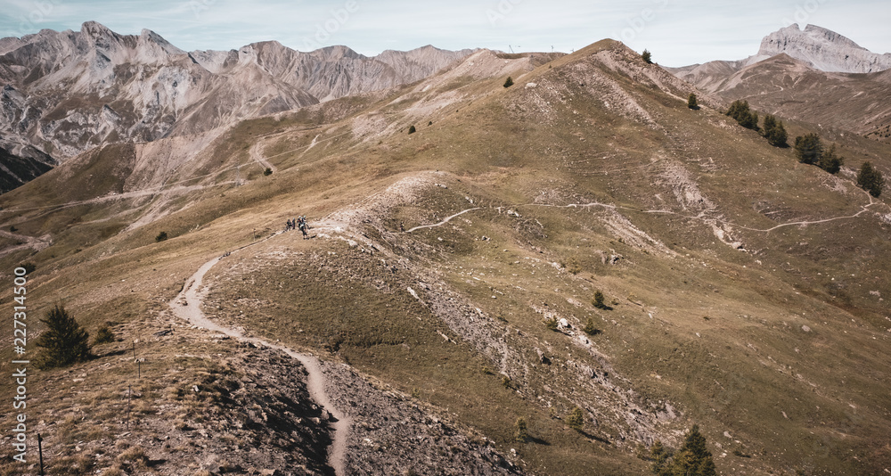 Mountain bikers in the distance preparing to climb towards the summit in the Alps