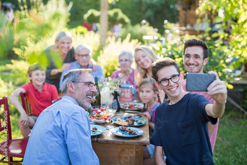 during a bbq a boy does a selfie with the whole family