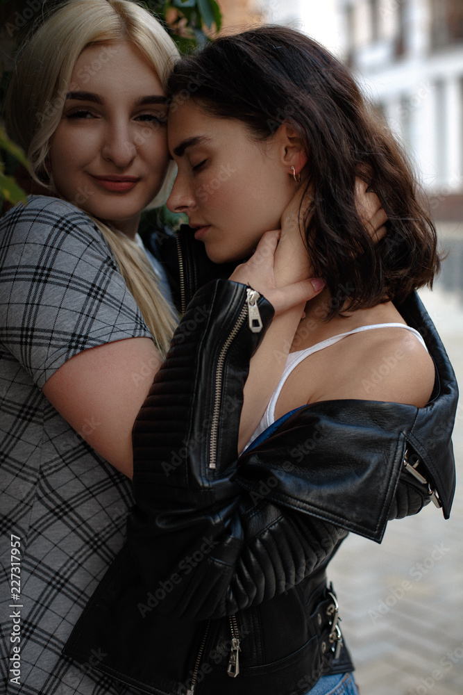 Foto Stock Attractive lesbian couple staying tight together. Wearing  fashion clothes. Lesbian love concept. | Adobe Stock