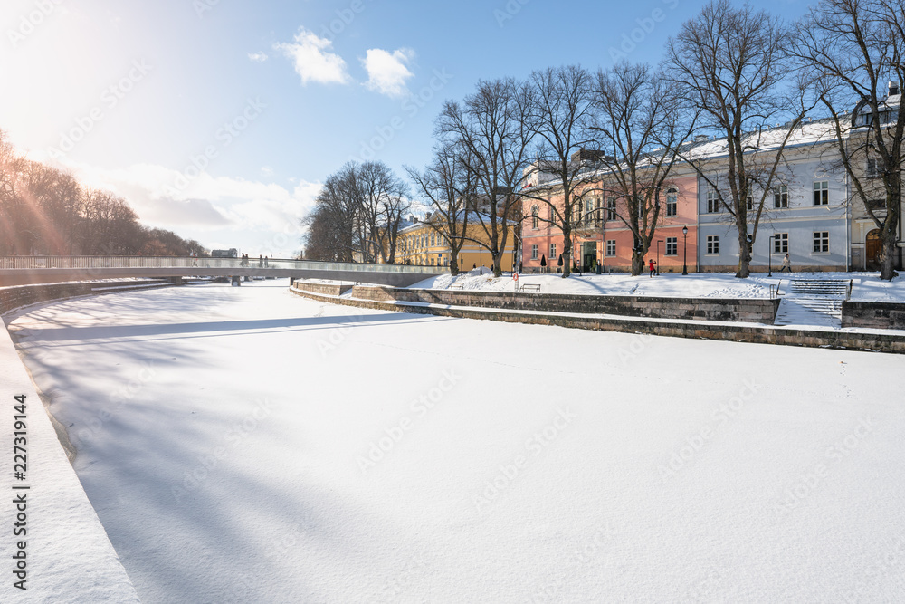 Colorful buildings by the shore of Aurajoki river at sunny winter day