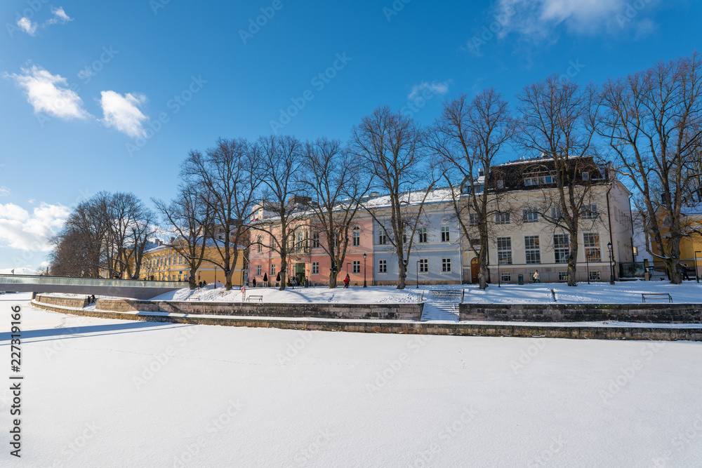 Colorful buildings by the shore of Aurajoki river at sunny winter day