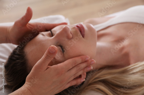 Woman enjoying head massage. Acupressure, reiki healing treatment. Relaxation and Alternative medicine concept photo