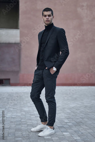 Confident young man walking on a European city street