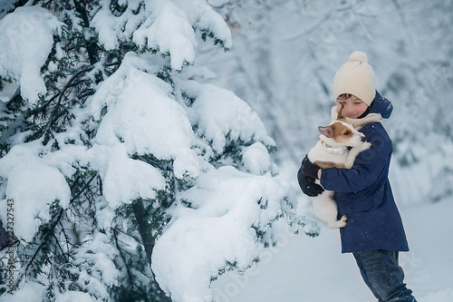 Boy in the winter forest is holding a puppy Jack Russell Terrier