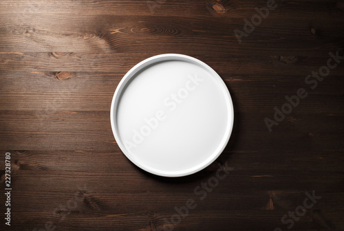Blank white plate on wooden background. Flat lay.