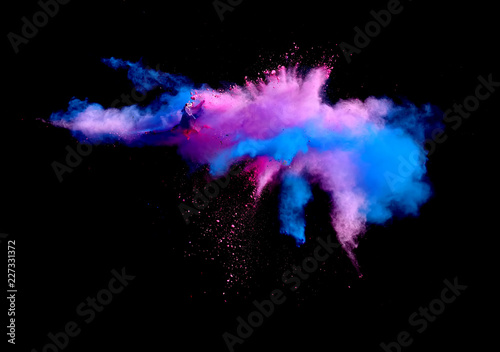 Abstract forms of powder paint and flour combined  together explode in front of a black background to give off abstract  multi colored cloud forms.