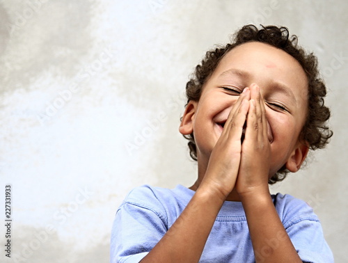 Fototapete little boy praying to god stock photo
