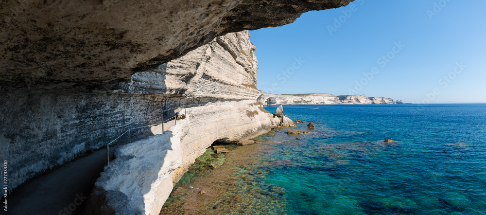 Φωτογραφία Panoramic view looking out from a coastal path cut into the side of a white limestone chalk cliff which leads to the King of Aragon staircase in Bonifacio, Corsica