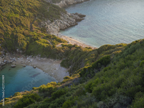 Corfu, Greece, Porto Timoni. View of the most famous double beach and bay in Afionas from the view point on the path. Sunset golden golden hour light