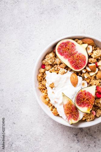 Muesli with Nuts Yogurt and fresh Figs on the gray Background.Granola Healthy Breakfast. Sweet food Dessert. Snack Dry Diet Nutrition Concept.Top View. Flat Lay.Copy space for Text