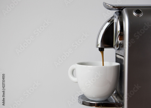 Coffee Espresso Pouring from Coffee Machine.  photo