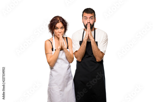 Couple of cooks keeps palm together. Person asks for something on isolated white background