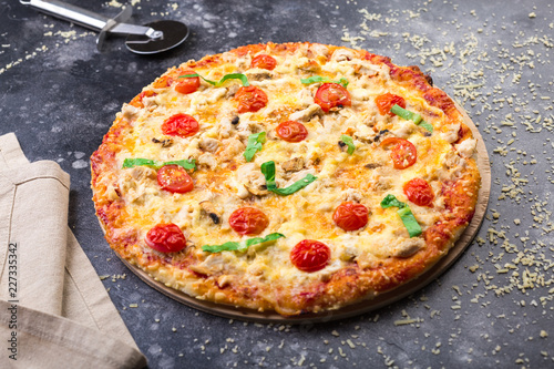 Pizza with chicken and tomatoes on a grey background. space for text