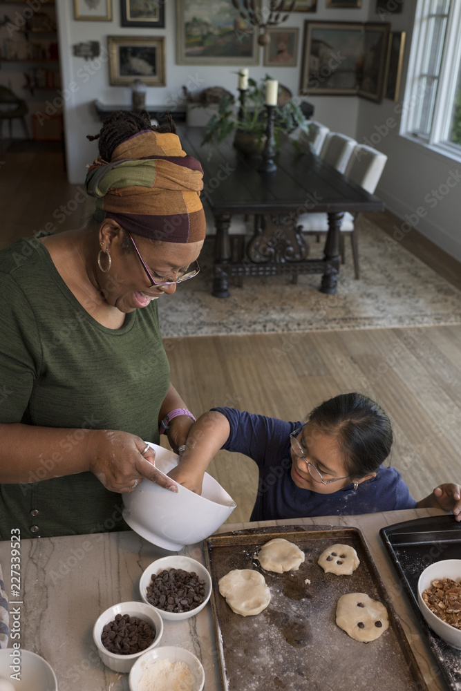 Woman teaching girl to make cookies