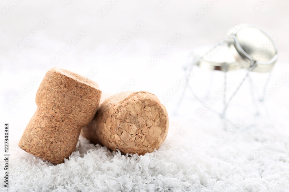 Fototapeta premium Champagne corks with caps on white snow