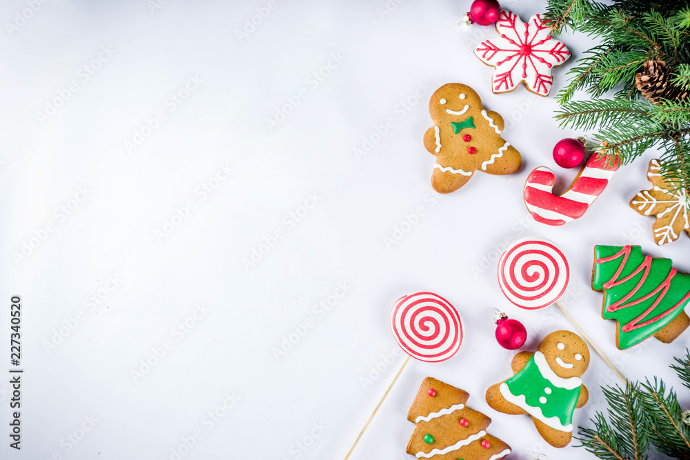 Various traditional colorful sugar glazed christmas gingerbread cookies, on white background top view copy space banner with xmas decorations