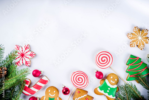 Various traditional colorful sugar glazed christmas gingerbread cookies, on white background top view copy space banner with xmas decorations