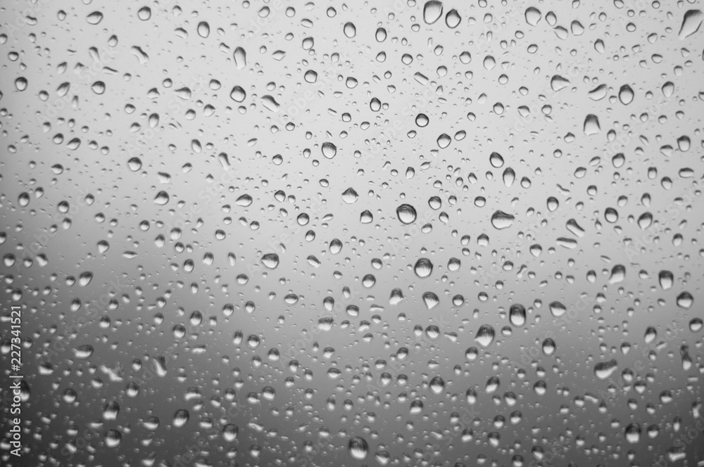 raindrops on window glass on background of cloudy sky raindrops on window glass on background of cloudy sky
