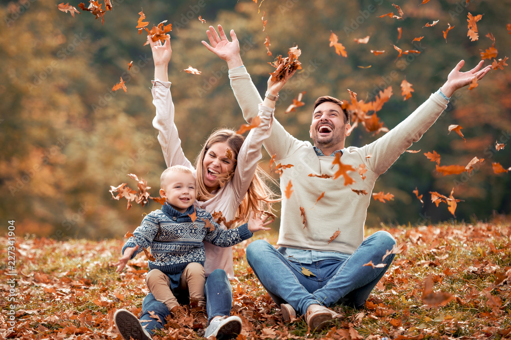 happy family in autumn park - obrazy, fototapety, plakaty 
