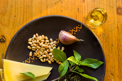 Fresh ingredients for preparing Italian pesto sauce - lemon basil sprigs, peeled seeds of cedar nuts, large garlic clove, Greek olive oil, Parmesan cheese photo