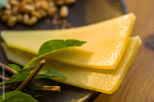 Fresh ingredients for preparing Italian pesto sauce - lemon basil sprigs, peeled seeds of cedar nuts, large garlic clove, Greek olive oil, Parmesan cheese