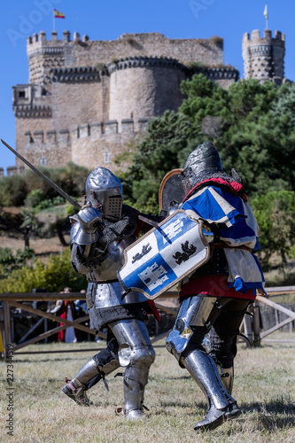 Medieval combat, with a castle in the background  photo