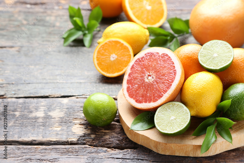 Citrus fruits with green leafs on wooden table Citrus fruits with green leafs on wooden table