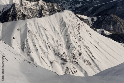 Top view of high grey mountain peaks covered with pure snow photo