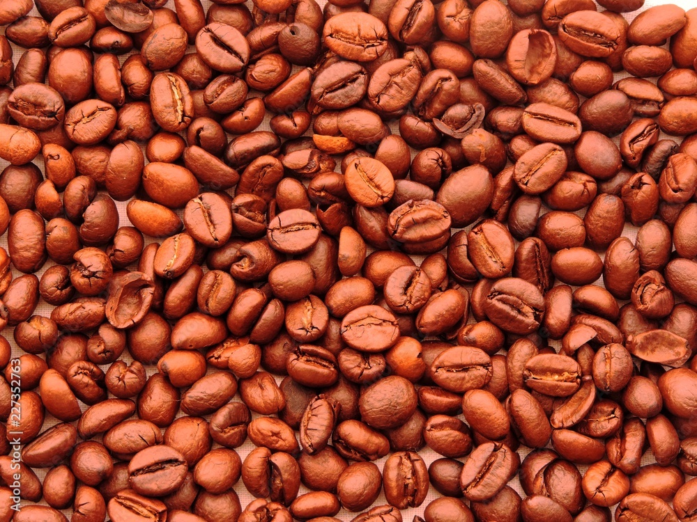 Top view of a dense bunch of roasted coffee beans in variety of reddish brown shades Top view of a dense bunch of roasted coffee beans in variety of reddish brown shades