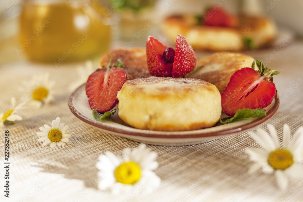 A large plate with curd cheese for breakfast, Cottage cheese pancakes, curd fritters with fresh berries strawberries with daisy flowers A large plate with curd cheese for breakfast, Cottage cheese pancakes, curd fritters with fresh berries strawberries with daisy flowers